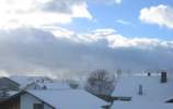 Schauerwolken jagen über den Himmel. Sonnenbeschienen wirbelt es in Roßhaupten den Schnee auf