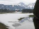 In einer teichgroßen Wiesenpfütze spiegeln sich die Berge