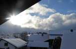 Foto: verschnete Dcher, dunkle Wolken, Sonnenstrahlen